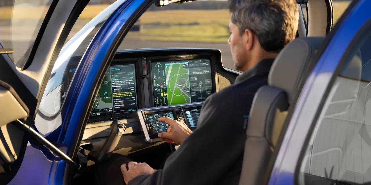 Pilot working the Perspective+ touchscreen controller in the left seat of a Cirrus